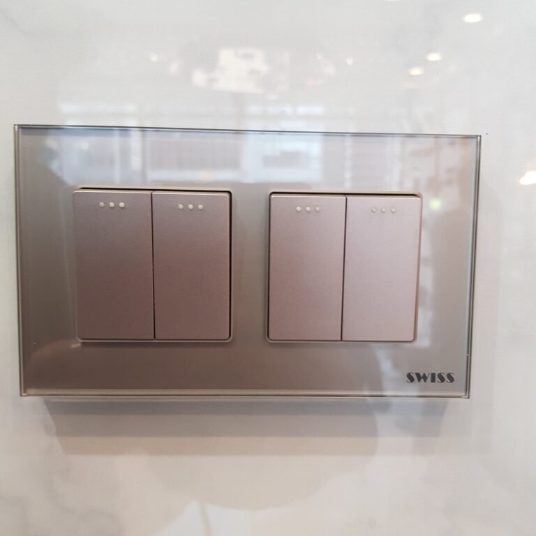Swiss glass switch plate with two double switches in a silver glass frame, on display