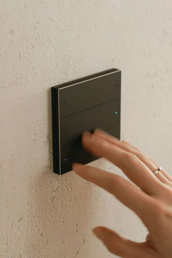 Hand pressing a wall-mounted smart scene switch